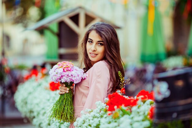 "Brunette girl holding bunch of flowers"