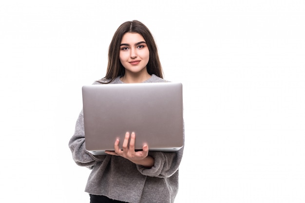 Brunette girl model in grey sweater stand and work studie on her laptop