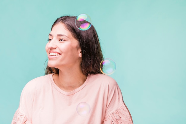 Brunette girl playing with soap bubbles