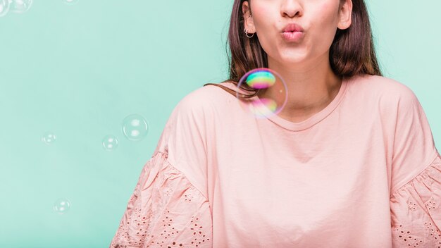 Brunette girl playing with soap bubbles