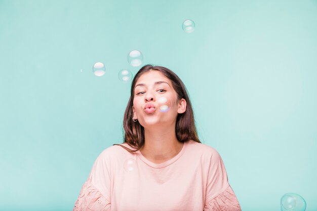Бесплатное фото Брюнетка играет с мыльными пузырями