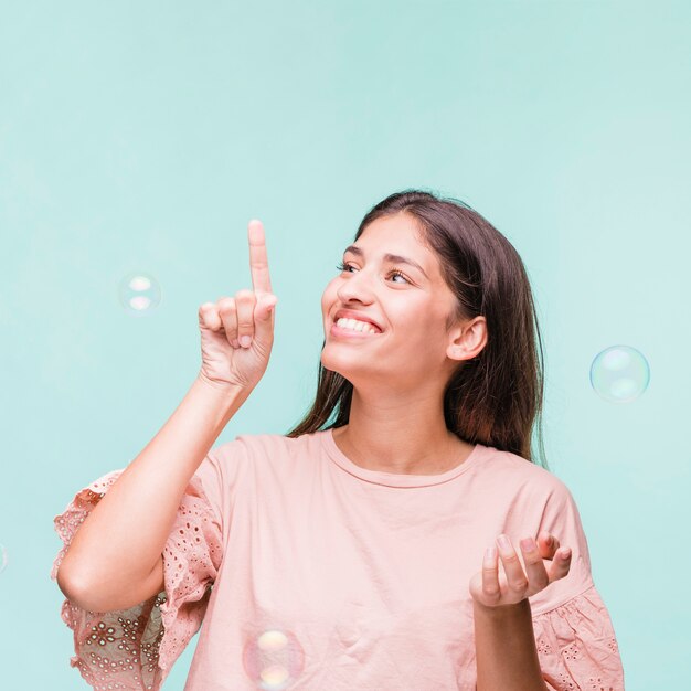 Brunette girl playing with soap bubbles