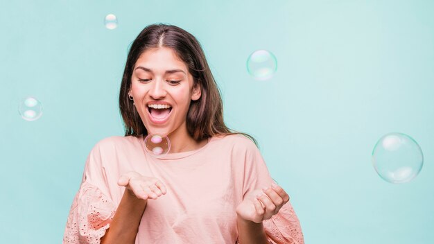 Brunette girl playing with soap bubbles