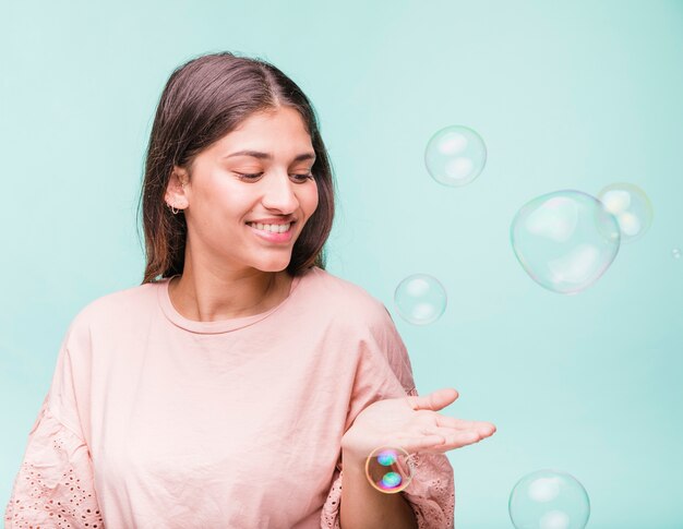 Brunette girl playing with soap bubbles