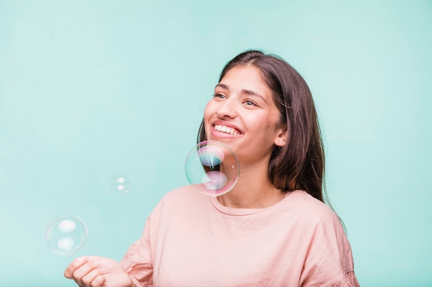 Brunette girl playing with soap bubbles