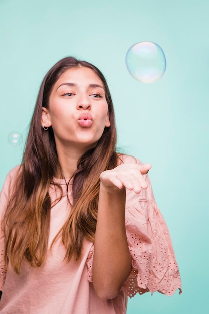Brunette girl playing with soap bubbles