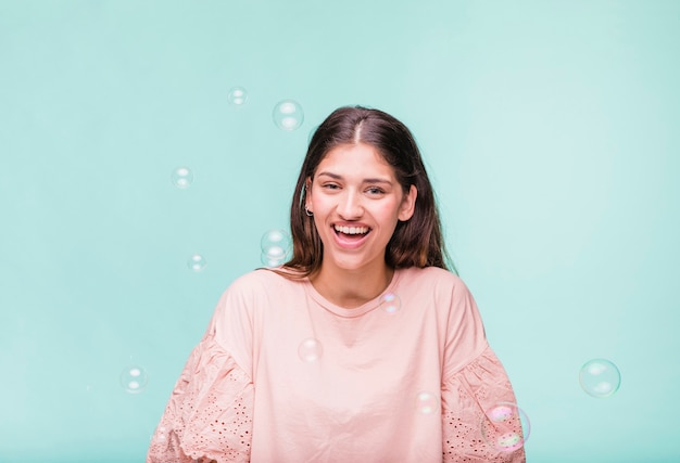 Brunette girl playing with soap bubbles