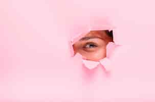 Free photo brunette girl posing through a paper hole