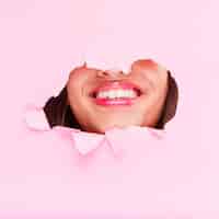 Foto gratuita ragazza bruna in posa attraverso un buco di carta