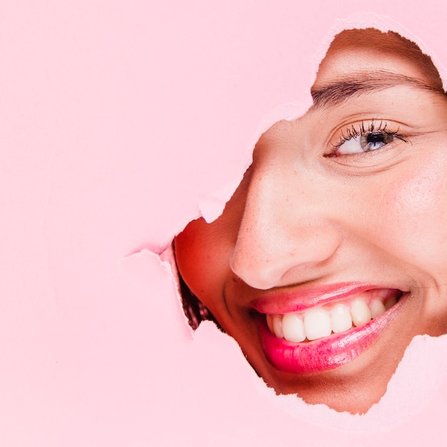 Free photo brunette girl posing through a paper hole