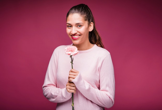 Free photo brunette girl posing with carnation