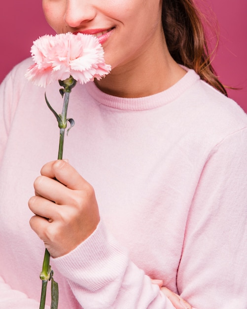 Free photo brunette girl posing with carnation