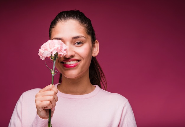 Foto gratuita ragazza bruna in posa con garofano