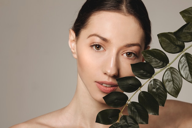 Brunette girl posing with exotic leaves