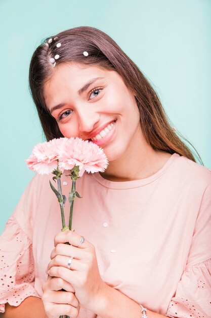 ブルネットの少女は花とポーズ