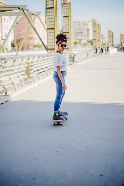 Foto gratuita ragazza bruna, cavalcare skateboard sulla strada