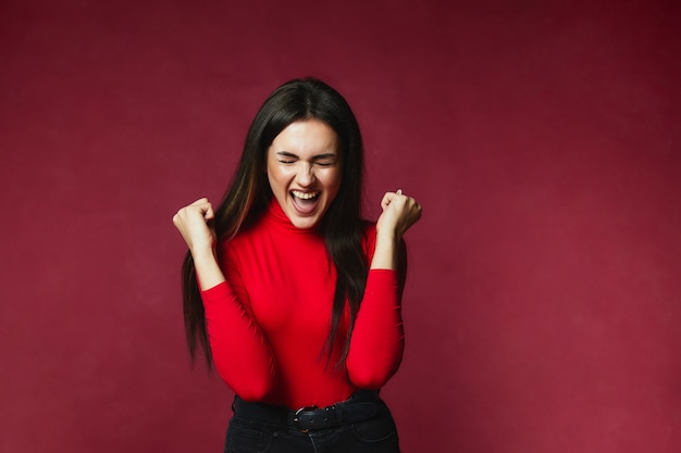 Brunette girl satisfied with victory with closed eyes