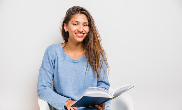 Foto gratuita ragazza bruna che si siede leggendo un libro