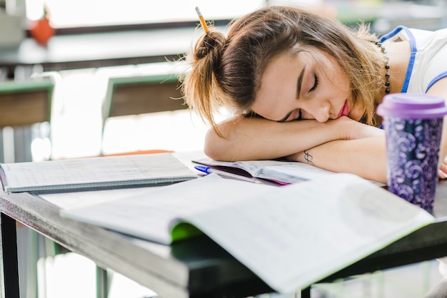 Brunette girl sleeping on table