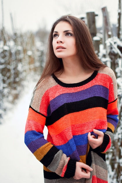 Brunette girl wearing a colorful pullover in the snow