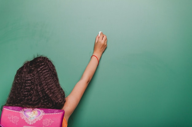 Free photo brunette girl writing on blackboard