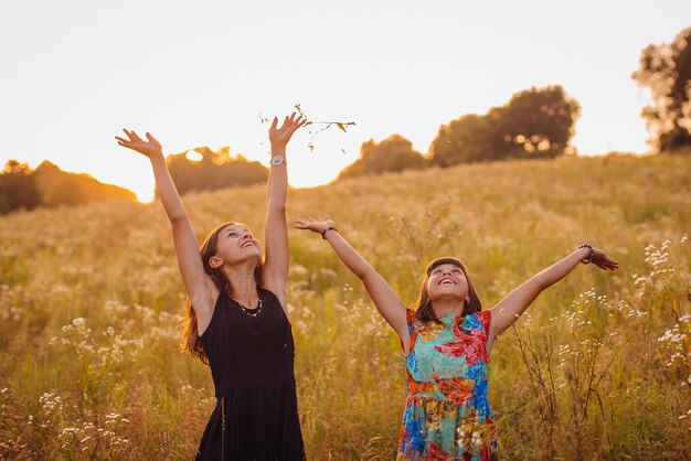 Brunette girls with daisies stand on the field 