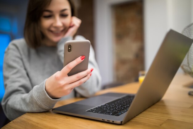 Brunette is watching funny videos during working on her laptop