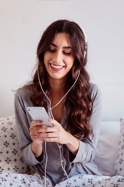 Brunette listening to music and browsing smarthone