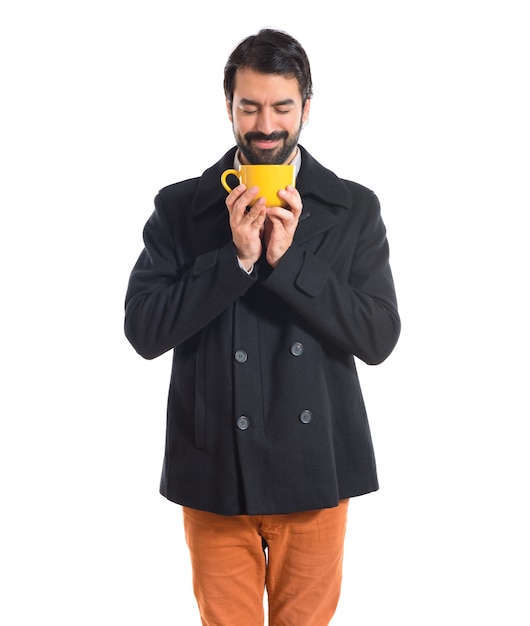 Free photo brunette man holding a cup of coffee