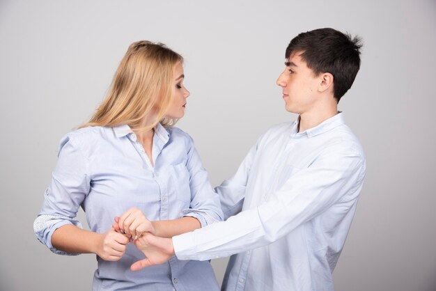 Brunette man model looking at blonde woman om gray background