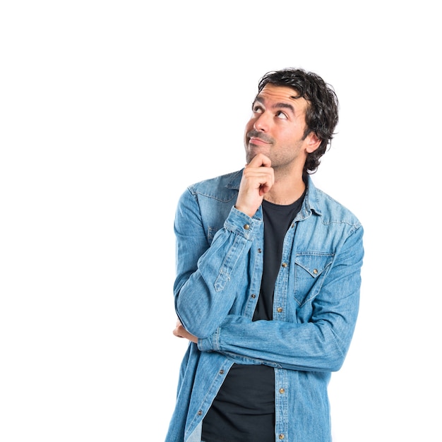 Brunette man thinking over isolated white background