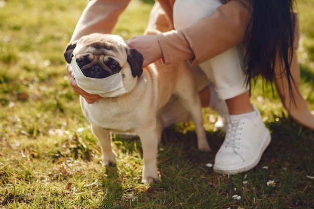 Brunette in a mask walks with pug