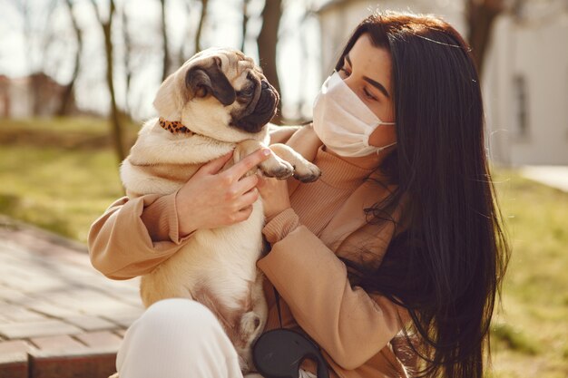 Brunette in a mask walks with pug