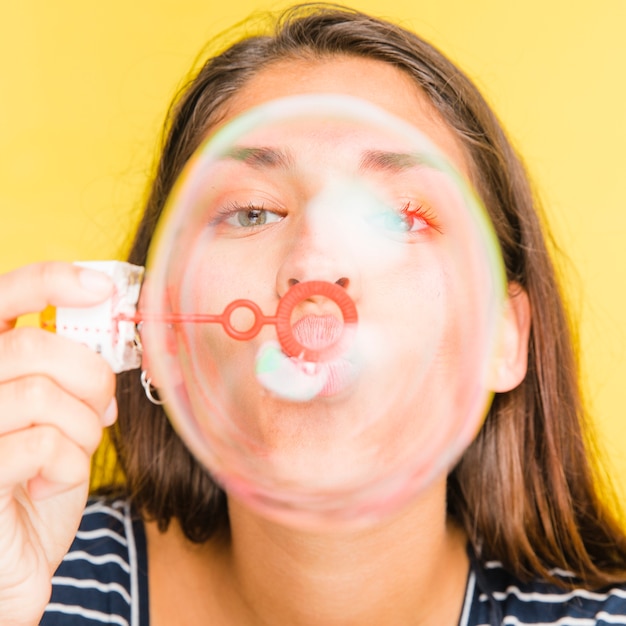 Free photo brunette model blowing bubbles