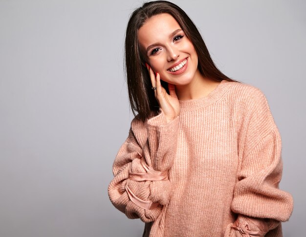 brunette model in casual beige warm sweater clothes on gray