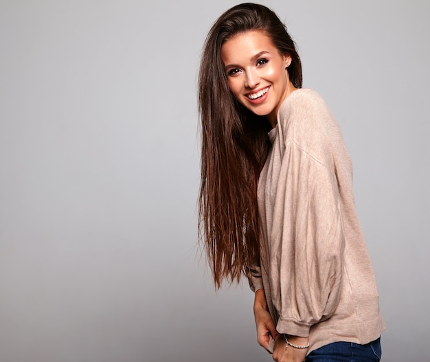brunette model in casual beige warm sweater clothes on gray