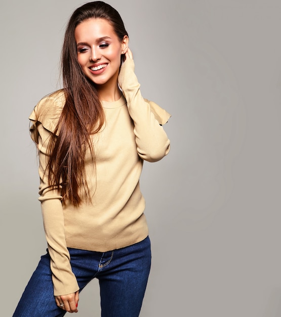 brunette model in casual beige warm sweater clothes on gray