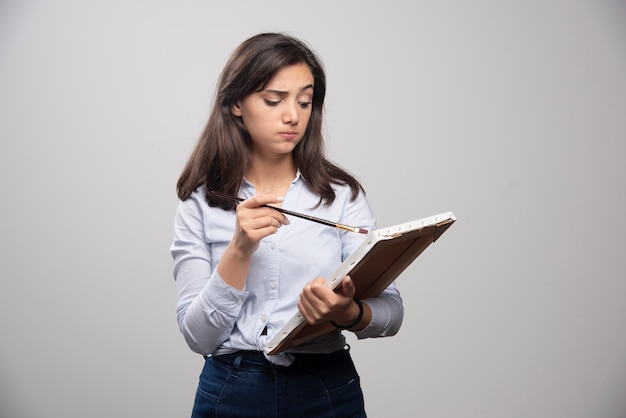 Brunette painter looking at empty canvas and thinking what to draw. 