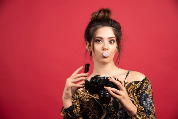 Brunette photograph girl chewing gum and checking photo history.