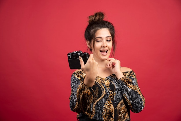 Brunette photograph girl taking her photos in smiling manner.