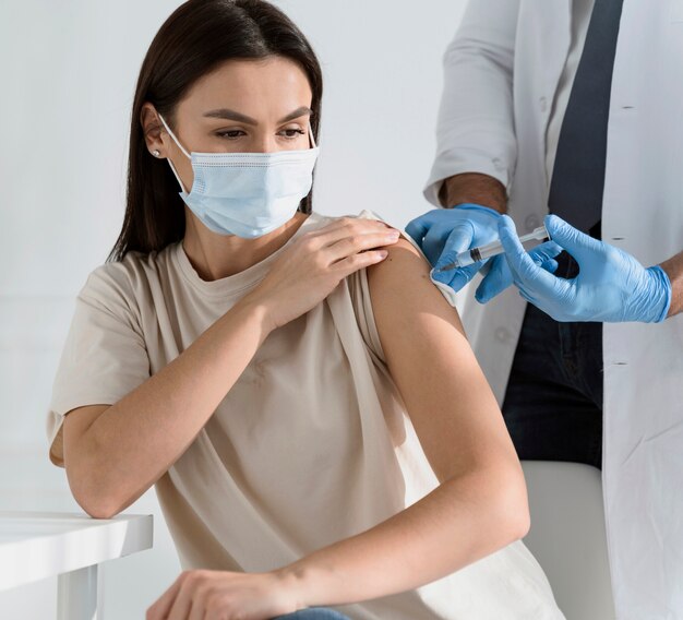 Brunette woman being vaccinated by doctor