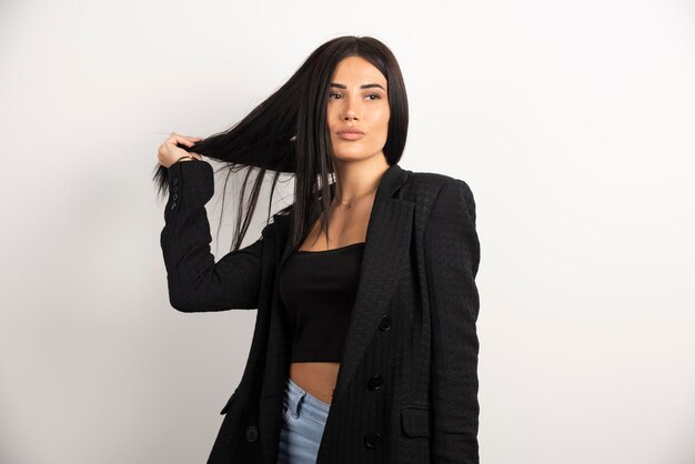 Brunette woman in black crop top playing with her hair. High quality photo