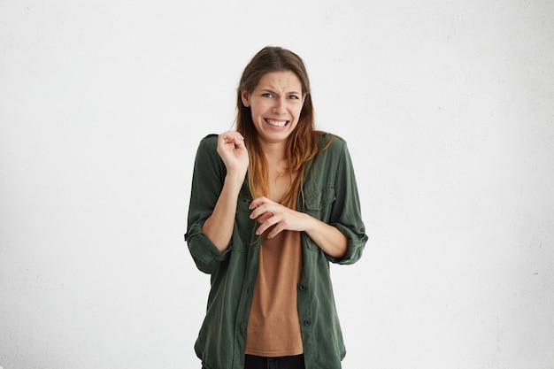 Free photo brunette woman in casual clothes expressing disgust, unwillingness, dislike, disregard having tensive look frowning face.