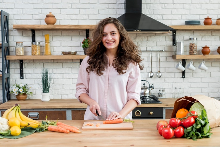 Free Photo brunette woman cutting carrots