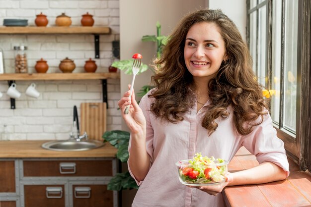 Brunette woman eating a salad