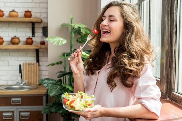 ブルネットの女性、サラダを食べる