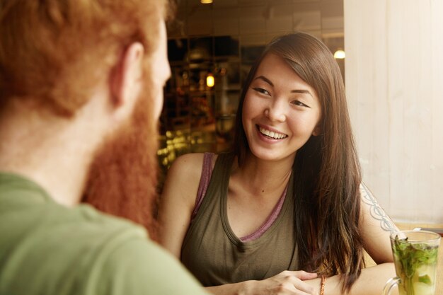 カフェに座っているブルネットの女性と生姜男