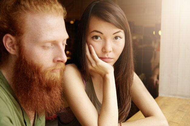 カフェに座っているブルネットの女性と生姜男