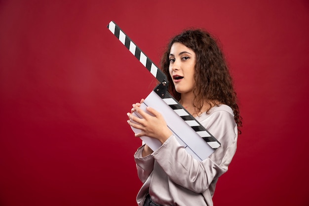 Brunette woman holding clapperboard