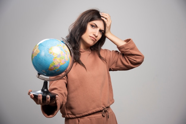 Free photo brunette woman holding globe having troubles